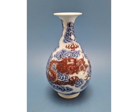 A Chinese underglaze red and blue vase painted with a dragon chasing a flaming pearl amongst blue clouds, six character mark.
