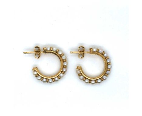 A pair of cultured pearl hoop earrings. Each earring is set with twelve pearls on 18ct gold hoops. Unhallmarked, with Egyptia