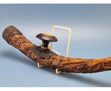 A Chinese carved bone opium pipe, the curved shape carved in relief with Guanyin, cranes, turtles and a dragon, the disc shap