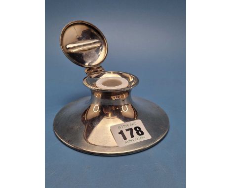 A silver capstan inkwell by Zimmerman, Birmingham 1902, the hinged lid indented with a pen rest, weighted, the base.   Dia. 1