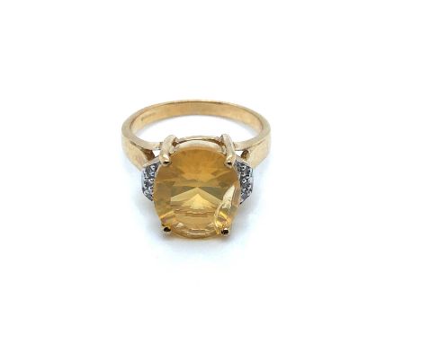 A 9ct hallmarked gold, fire opal and diamond ring. The central oval fire opal measurements 12.1 x 10.1 mm, held in a four-cla