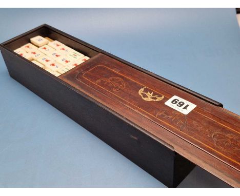 A cased bone and bamboo mahjong set, the slide off lid of the ebonised box inlaid with shaped reserves of bamboo.   W 35cms