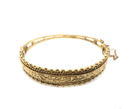 A vintage 9ct hallmarked gold Victorian-style hinged bangle complete with a safety chain. Weight 18.1 grams. 