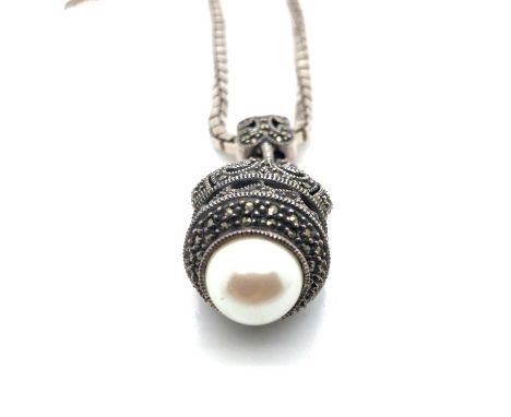 A marcasite and faux pearl ornate pendant suspended on a heavy box link chain. The pendant unhallmarked, assessed as silver t