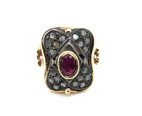 A vintage ruby and diamond ring. The central oval ruby in a rub-over setting is surrounded by a cushion of old-cut diamonds. 