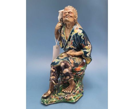 A Japanese green Kutani figure of Gama Sennin seated on a rock with his familiar three legged toad on his shoulder.   H 25cms
