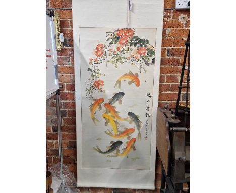 A Chinese scroll depicting goldfish swimming below flowering camelias, inscribed to one side and with a red seal mark.   130 