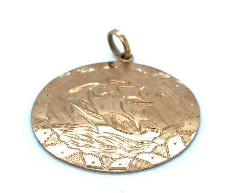 A vintage large disc pendant with an engraving of a ship at sea. Unhallmarked, assessed as 18ct gold. Diameter 3.5 cm. Weight