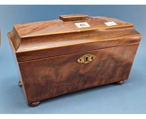An early 19th Century line inlaid mahogany sarcophagus tea caddy on bun feet, the interior now paper lined