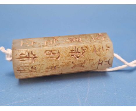 A Chinese jade roller seal pendant, each of the eight sides carved with four characters.   H 5.5cms