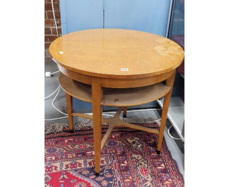 A Heal's type circular table with an open shelf below the top, the tapering square sectioned legs joined by an X-shaped stret