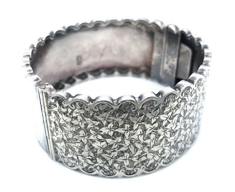 A Victorian hallmarked silver scallop edged hinged bangle. Dated 1885. Weight 29.1 grams. 