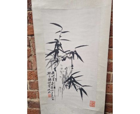 A Chinese scroll depicting bamboo growing by rocks, inscribed and with red seal marks.   65 x 35cms.