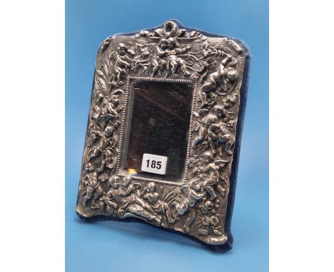 A Sterling Silver framed velvet easel backed mirror, the frame cast with amorini amongst flowers.   27 x 22cms