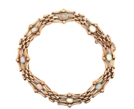 A vintage 9ct gold and opal gate bracelet. Eight oval opals each individually set into the centre of a three-bar gate, comple