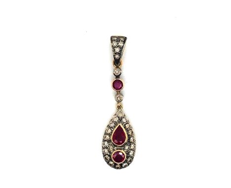 A ruby and diamond teardrop articulating pendant. Unhallmarked, the bail stamped 750, the pendant assessed variously between 