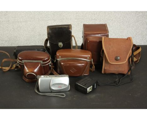 A collection of seven vintage 35mm cameras and others. Makers include Kodak, Olympus, Paxette, Agfa and Brownie, some with ca