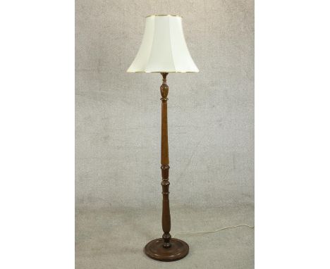 A 20th century stained beech standard lamp with a turned and reeded stem on a circular base, with a white shade. H.175 Dia.36