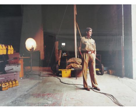 A large framed and glazed photographic print of Harrison Ford on set.  H.85 W.110cm 