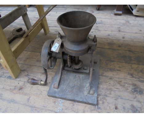 Small metal corn grinder on stand