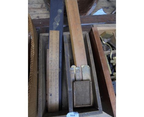 Old wooden box containing a number of vintage wooden tape measures and measuring tools
