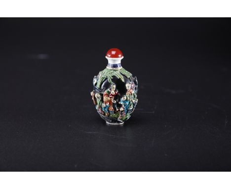 Arte Cinese . An enamel painted famille noir molded in relief porcelain snuff bottle and stopper bearing an incised Qianlong 