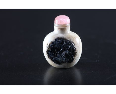 Arte Cinese . A black and white  jade snuff bottle decorated with vegetal motifs. Tourmaline stopper. China, Qing dynasty, 18