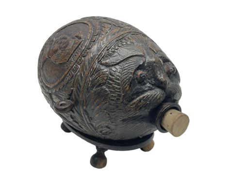 19th century bug bear flask carved with Balkan figures, a wolf and leafage with glass eyes, L14cm on stand 