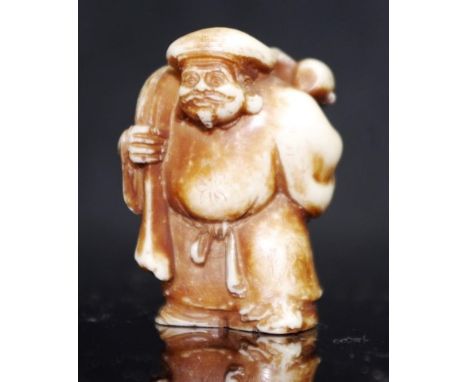 Japanese carved figural netsuke figure of a standing man carrying a sack, (height 4cm approx)