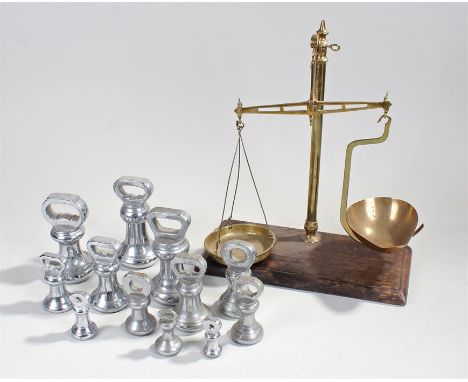 Scale set and bell weights, the scales with brass pans and arm, together with a selection of bell weights