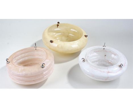 Three glass lamp shades, a white glass example in marble effect, a pink glass example in marble effect and a yellow glass exa