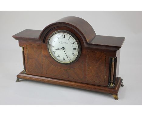 An early 20th century inlaid mahogany mantel clock, rectangular dome case with column supports, circular white enamel dial ma
