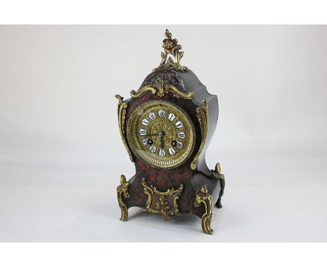 A 19th century Parisian boulle mantel clock with scrolling brass mounts on waisted case, the gilt dial with Roman numerals on