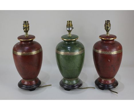 A pair of red baluster shape table lamps with marbled effect decoration and gilt band, and another single lamp in green, 30cm