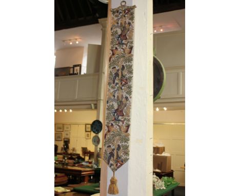 A medieval style tapestry wall hanging depicting a boy and birds in a fruit tree, with gilt mounts, 110cm total length