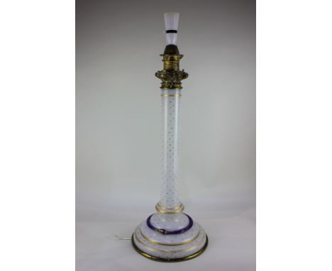 A white glass table lamp, cylindrical stem, decorated with gilt stars, the circular base encircled with a blue and gilt snake