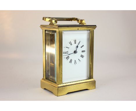 A brass and bevelled glass cased carriage clock, the white enamel dial with Roman numerals, 15cm high