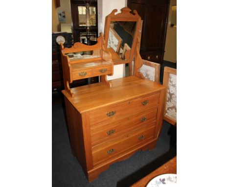 A satinwood dressing chest, raised back with mirror panels, shelf and two small drawers above three graduated drawers, on sha