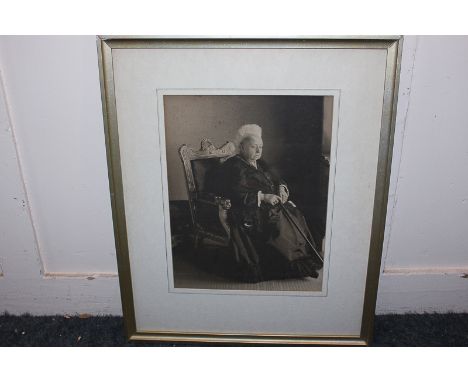 A framed sepia print of Queen Victoria dressed in mourning gown, seated on a gilded throne, 30.5cm by 23cm