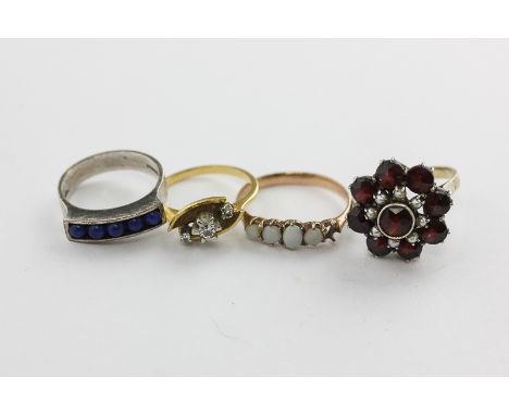 A garnet and seed pearl cluster ring, an opal ring (one stone missing), a diamond three stone ring claw set with round brilli