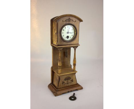 An early 20th century oak cased miniature long case style clock, the case with floral scroll design and open frame with expos
