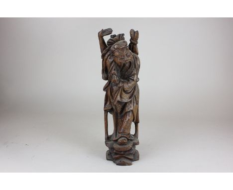 A Chinese carved wood figure of a sage with arm raised, wearing cloak, with metal wire inlay, 35cm high