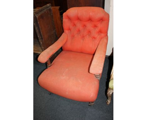 A Victorian mahogany framed button back armchair with padded open arms, on turned front legs and castors (a/f)