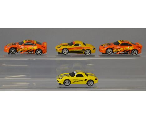 Four unboxed Scalextric digital slot cars, including two Nissan cars, a Boxster and a C2479D Porsche Boxster in yellow, overa