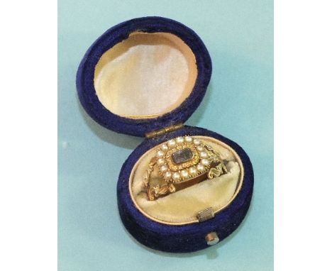 A Georgian mourning ring set with plaited hair panel, within engraved and pearl-set borders, between pierced shoulders, (dama