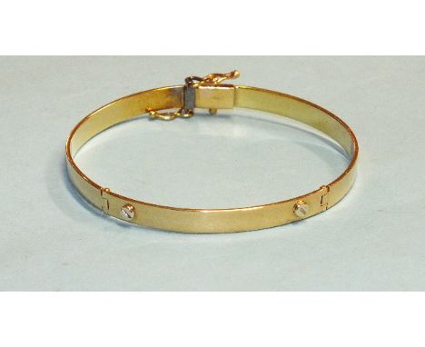 An 18ct yellow gold double-hinged bangle with screw-head decoration, 5.7 x 5cm, 14.5g, cased.