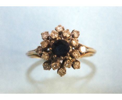 A sapphire and diamond cluster ring set a round-cut sapphire and sixteen 8/8-cut diamonds, in unmarked gold mount, size V, 5.