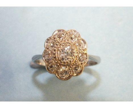 An Edwardian diamond cluster ring set nine old brilliant-cut diamonds, in platinum mount, size J½, 3.4g.