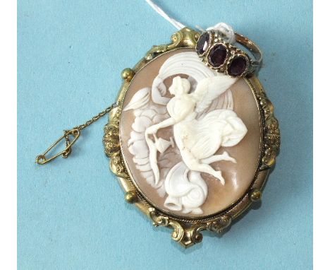 A shell cameo brooch depicting an angel and a three-stone garnet ring, unmarked, (2).