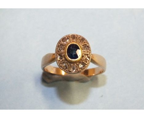 A sapphire and diamond cluster ring collet-set an oval sapphire within a border of ten rose-cut diamonds, in unmarked gold mo